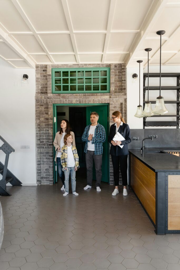 A family touring a modern home interior with a real estate agent, considering a purchase.